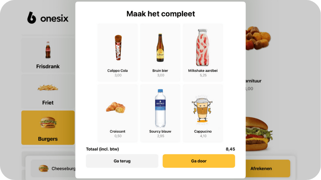 Menu screen with 'Maak het compleet' titled upsell options including Calippo Cola, Bruin bier, Milkshake aardbei, Croissant, Sourcy blauw water, and Cappuccino with prices and buttons to go back or continue.